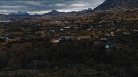 Polygonal-Geodesic-camping-tents-on-turfy-mountain-hill,-Mexico,-revealing-shot