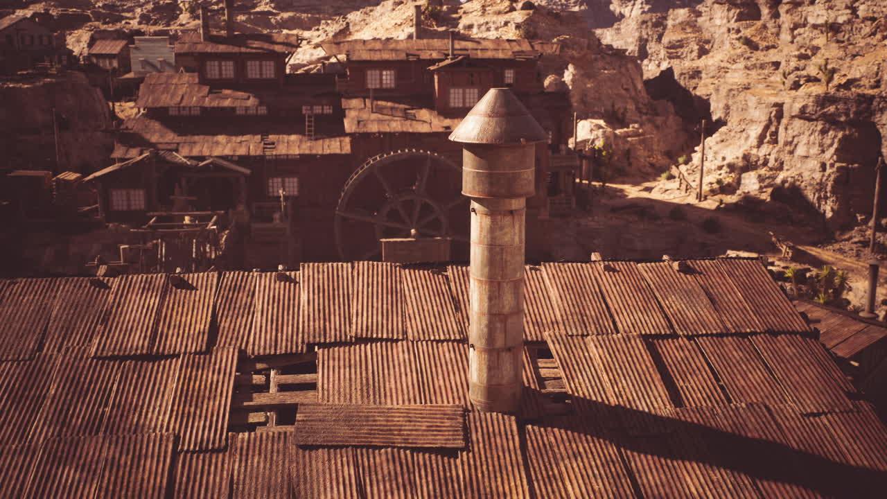 Historic mining town with rusted buildings and a tall chimney in daylight