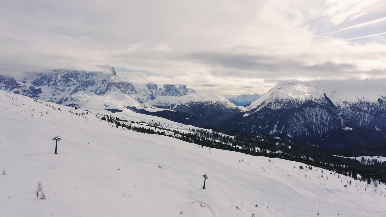 Sorvolo aereo di un bellissimo paesaggio invernale con le famose Pale di San Martino sullo sfondo.