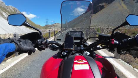 pov biker rides on motorbike by scenic mountain pass in swiss alps, moto trip