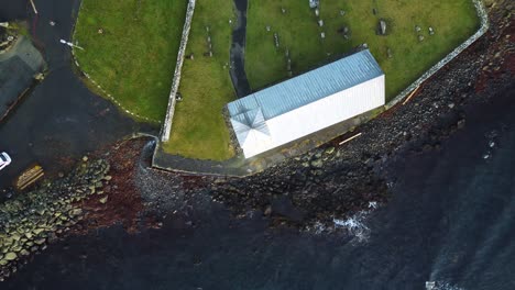 drone sunset shot from above of church in kirkjubour village in the faroe islands on sunny summer day