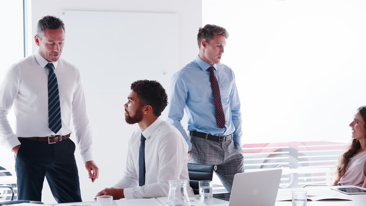 Businessmen And Businesswomen Meeting Around Table In Modern Boardroom Shot In Slow Motion