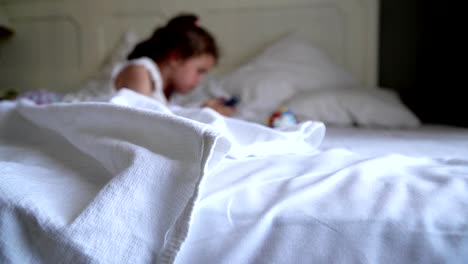 little girl playing on the bed