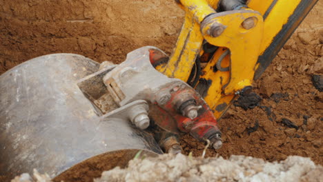 trabajos de excavación en un sitio de construcción el cucharón de la excavadora levanta el suelo