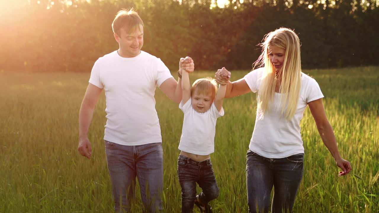 familia feliz, madre padre e hijo en un paseo emocional. corriendo y disfrutando de la vida en un campo verde en el aire fresco, cielo azul, naturaleza