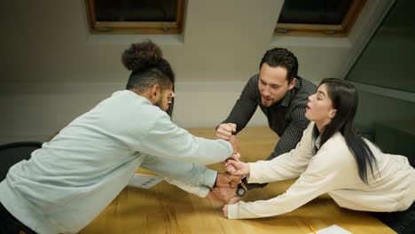 team of entrepreneurs stacking fists to a tower in conference room