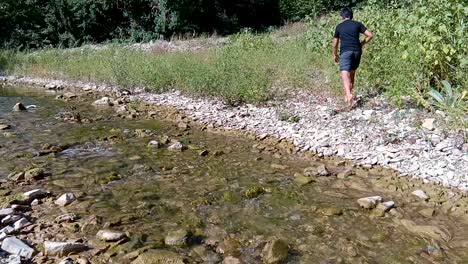 child walking through a shallow stream