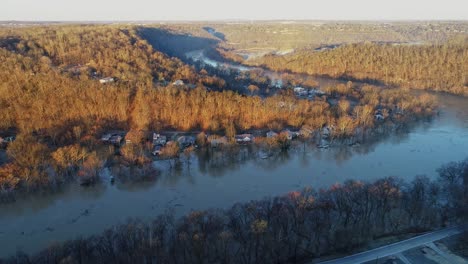 aerial of kentucky forest hills at golden hour sunset with river flooded homes