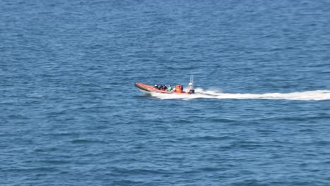 Hand-held-tracking-shot-of-a-high-powered-RIB-boat-splashing-off-the-coast-of-Newquay