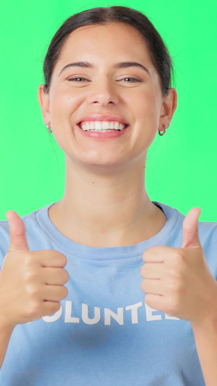 Smiling Volunteer Giving Thumbs Up Against Green Screen