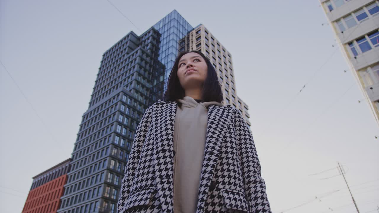 retrato de ángulo bajo de una joven adulta asiática en el distrito del centro de la ciudad