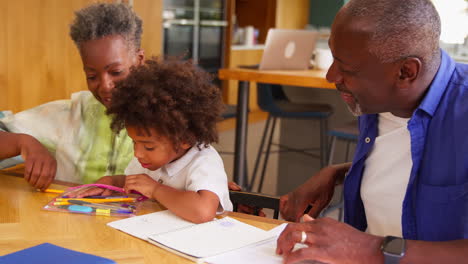 multi-generation family with grandparents helping grandson with school work at home