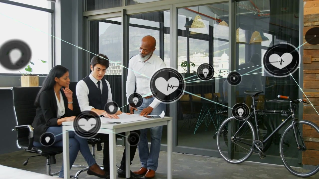 Driekoppig team dat aan een technologiedesk documenten doorneemt, waarbij een startend hartpictogram de groep verbergt