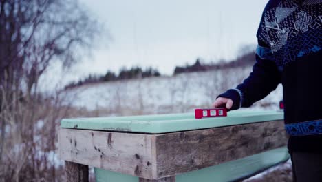 a man is using a level to ensure the surface of the diy hot tub is even - static shot