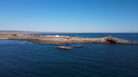 el retroceso aéreo revela sobre la costa tropical de bahía asunción, baja california sur, méxico, mientras las gaviotas pasan corriendo.