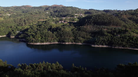 el establecimiento de un tiro de empujón revela una montaña llena de árboles y un río calmante que fluye por debajo