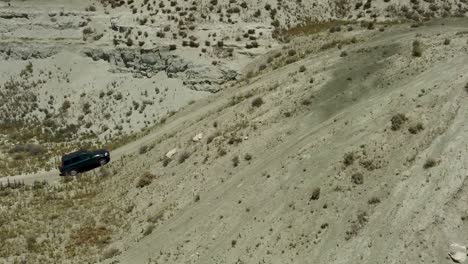 Toma-Aérea-Enfocada-En-Un-Vehículo-4x4-Que-Intenta-Subir-Una-Fuerte-Pendiente-De-Tierra,-Y-Fracasa-En-El-Intento