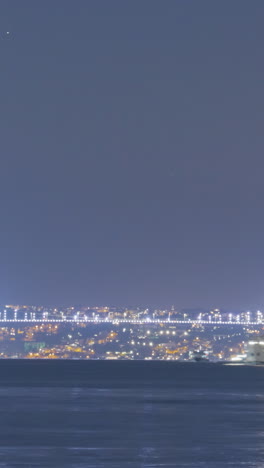 horizonte nocturno de la ciudad con puente sobre agua congelada