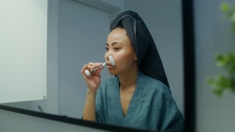 mujer haciendo masaje facial en el baño
