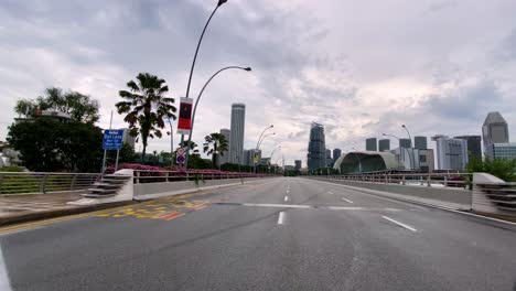 empty sidewalk near highway road with cityscape at background in singapore during corona virus pandemic