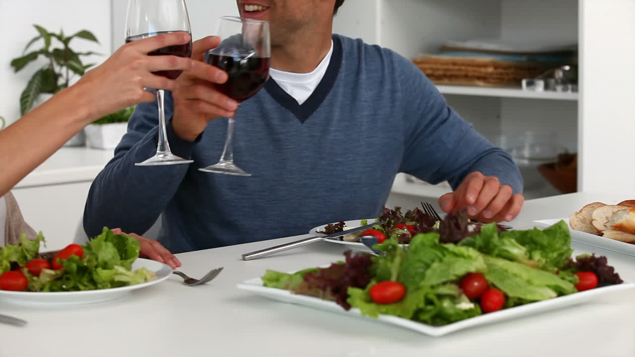 una pareja tiene una cena feliz mirando a la cámara.