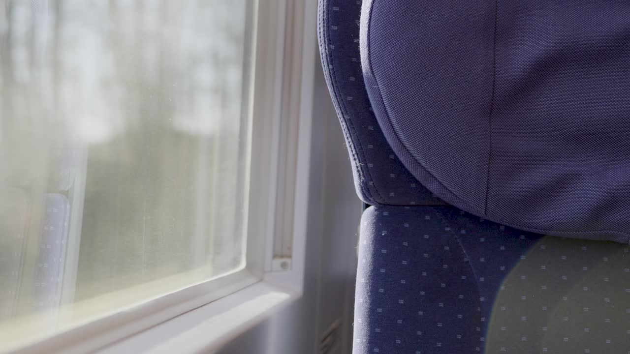 Inside a German ICE train, focusing on the seat next to the window with blurred scenery