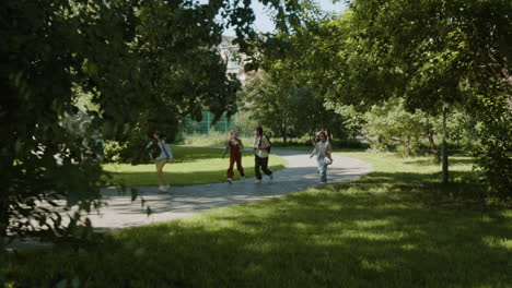 students walking along a path in a sunny park