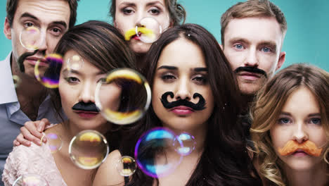 Grupo-Multirracial-De-Personas-Con-Bigote-Falso-Para-El-Fotomatón-De-Fiesta-En-Cámara-Lenta-De-Movember