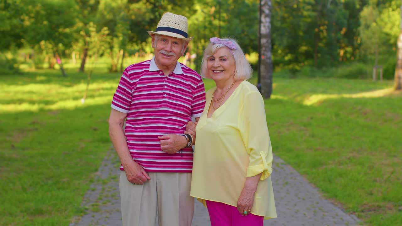 노인 스타일리시 관광객 커플 할머니, 할아버지가 여름 공원에서 고 키스를 하고 있습니다.