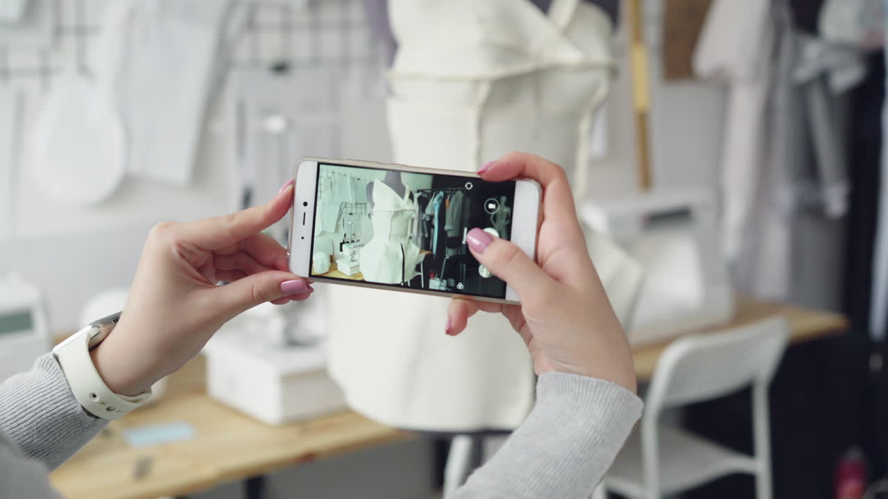 Woman taking a photo of a dress design in a fashion studio