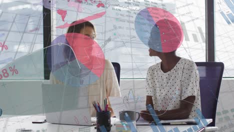 animation of charts and processing data over two diverse businesswomen discussing in office