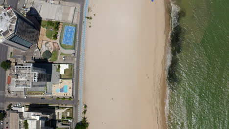 high angle shot of jaboatão dos guararapes beachfront pernambuco brazil with its distinctive sea white sand clear blue sky coastal buildings perfect for summer holidays featuring a boat and sunshade.