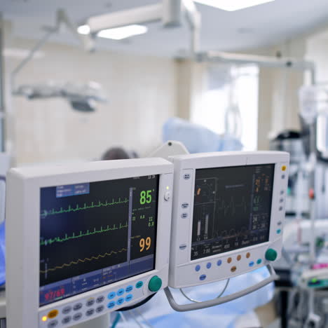 approaching switched on monitors of lung ventilating machine. double screen show the life parameters of operated patient.