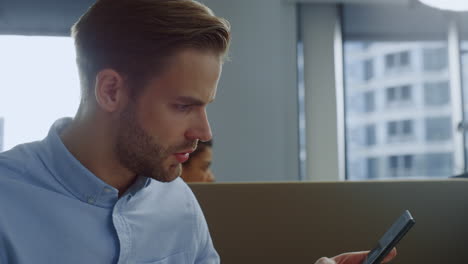 Businessman-working-on-laptop-in-open-space.-Worker-answering-on-phone-call