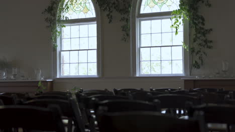 chairs empty at wedding venue natural light shines through windows
