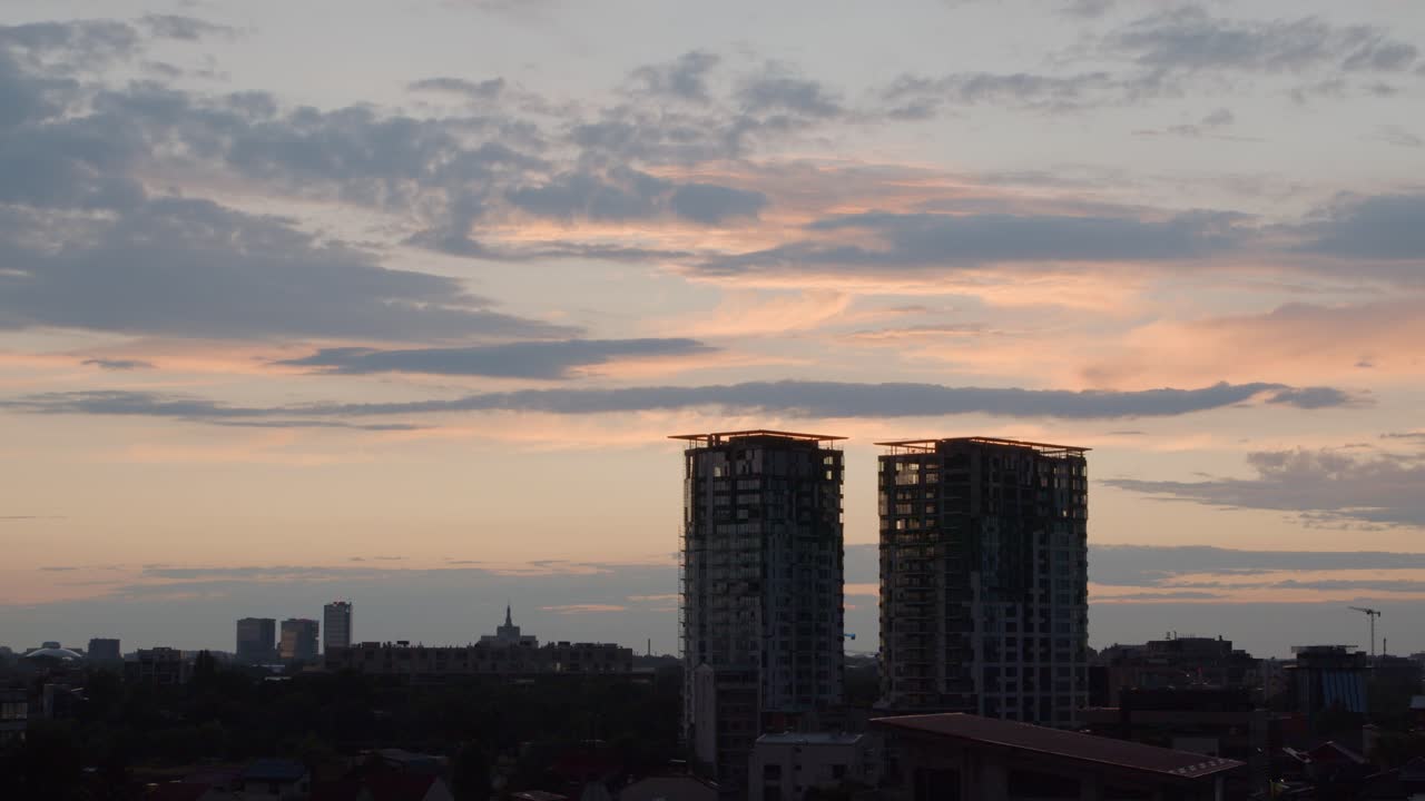Paisagem urbana com torres em um pôr do sol nublado alaranjado