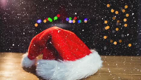 Animation-of-snow-falling-over-santa-hat-and-colorful-bokeh