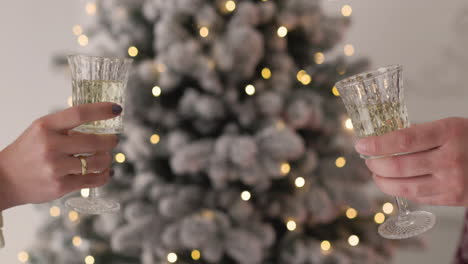 close up of an unrecognozable couple toasting with chamapgne glasses on christmas