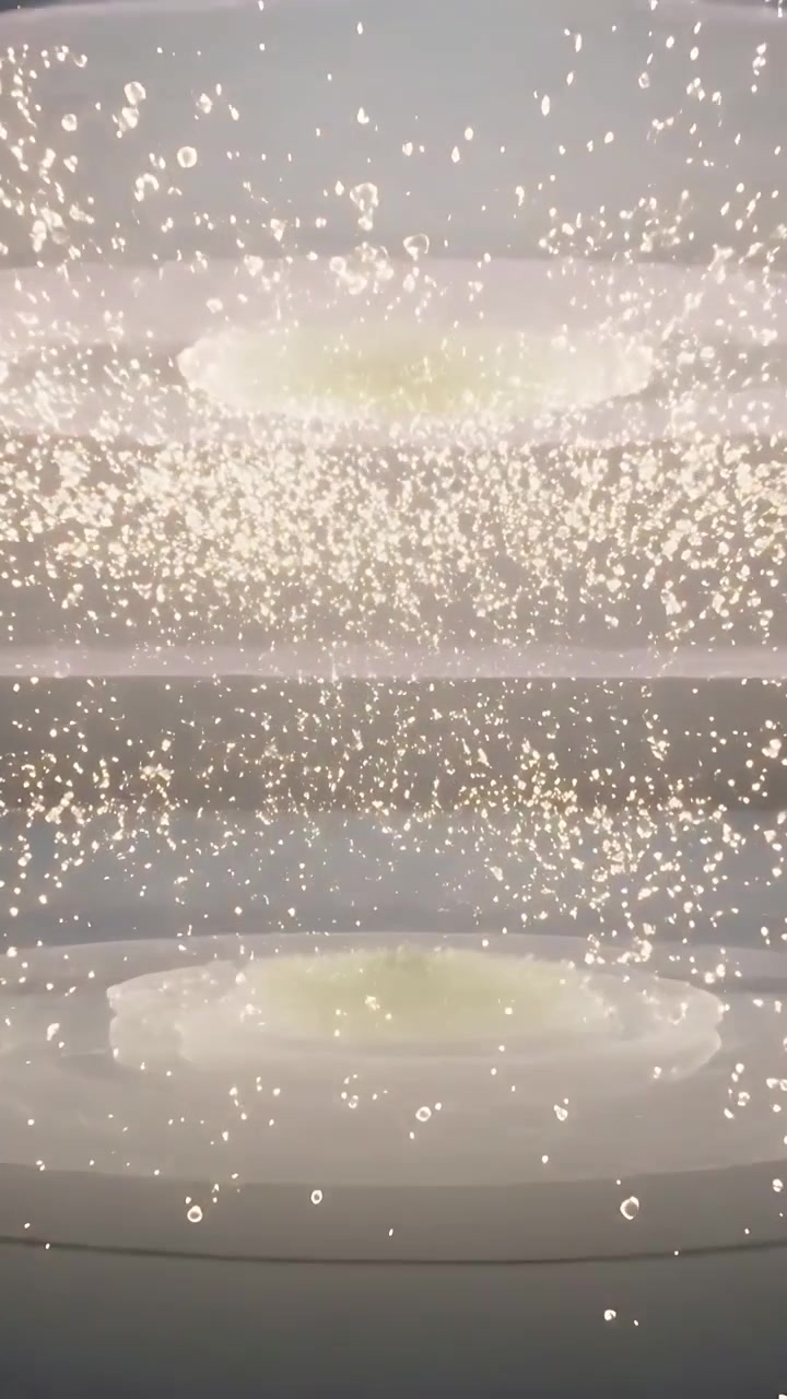 Video verticale: Scintille che esplodono e si spostano formando una tenda, poi anelli gemelli sopra il palco che si stabilizzano per brillare.