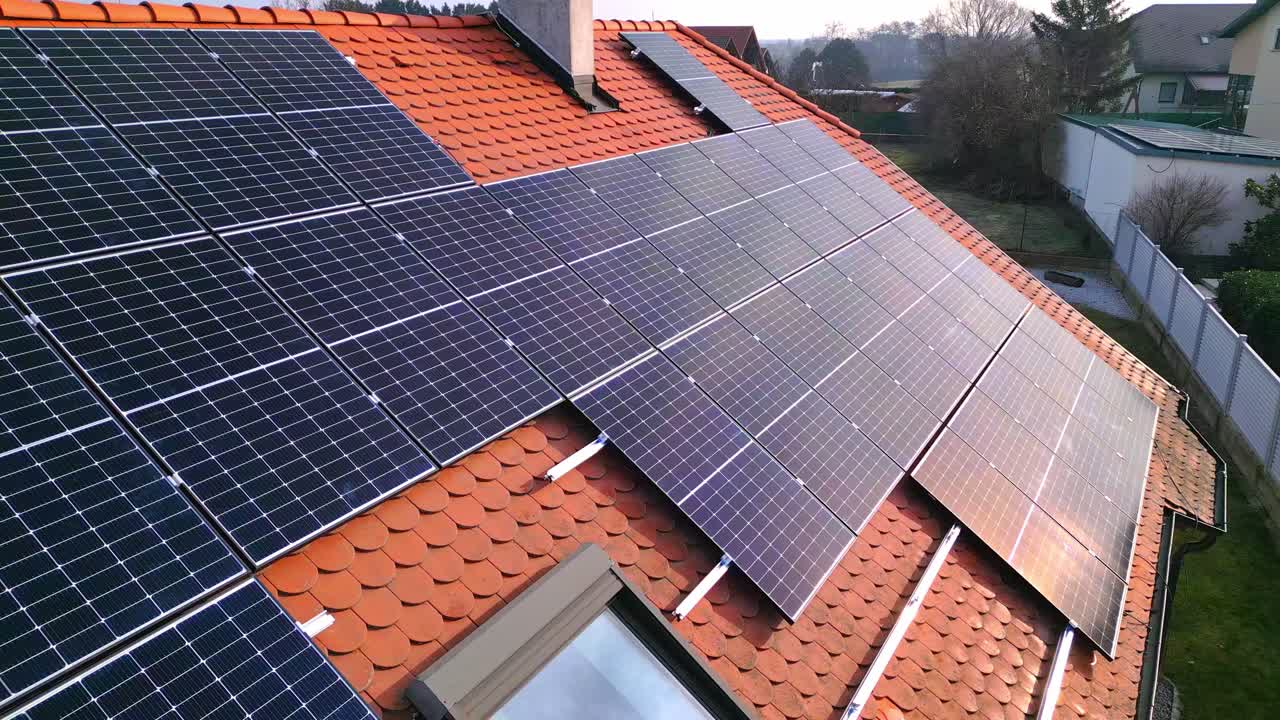 Solcellepaneler på det røde tegltag i en landsby på landet