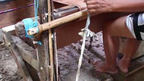 trabajadores tejiendo hilo en tela usando telares tradicionales, video de poca luz en una habitación oscura, pekalongan