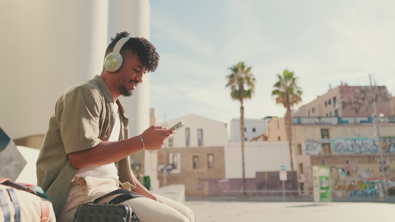 Man with headphones using smartphone in an urban environment