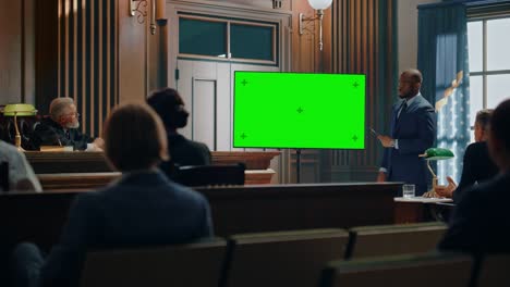 court of law trial in session: portrait of charismatic male public defender showing evidence on green screen tv display to judge and jury. attorney lawyer protecting client, presenting case.