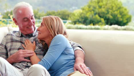 Senior-couple-sitting-together-on-sofa-in-living-room