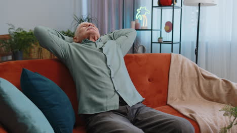 tired senior man enjoy relaxing on home sofa resting napping after hard working day closed his eyes