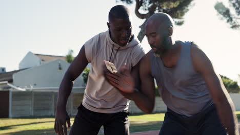 two men playing basketball outside