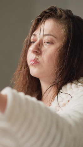 dama con el cabello mojado limpia el espejo después de los procedimientos de baño en el lugar de casa. mujer limpia la niebla del espejo de la ducha con una toalla en el baño de luz en cámara lenta