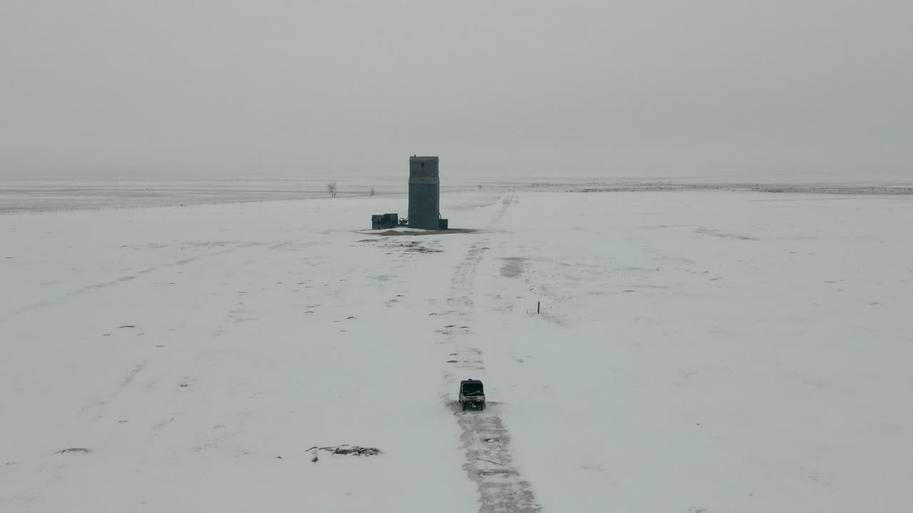 겨울에 눈 덮인 들판을 통해 utv를 나란히 따라가는 공중, 4k