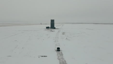 Antena-Siguiendo-Utv-De-Lado-A-Lado-A-Través-Del-Campo-Cubierto-De-Nieve-En-Invierno,-4k