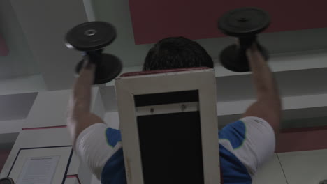 체육관에서 덤벨을 들고 훈련하는 남자